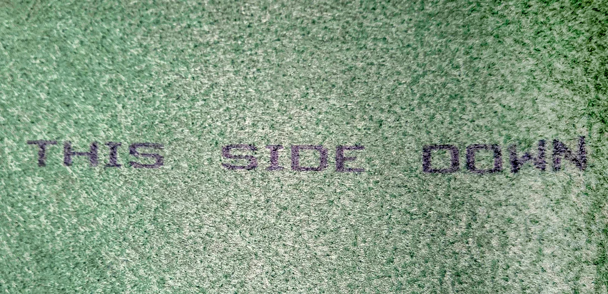 Inscripția „THIS SIDE DOWN" de pe prelată, indică fața orientată spre baloți